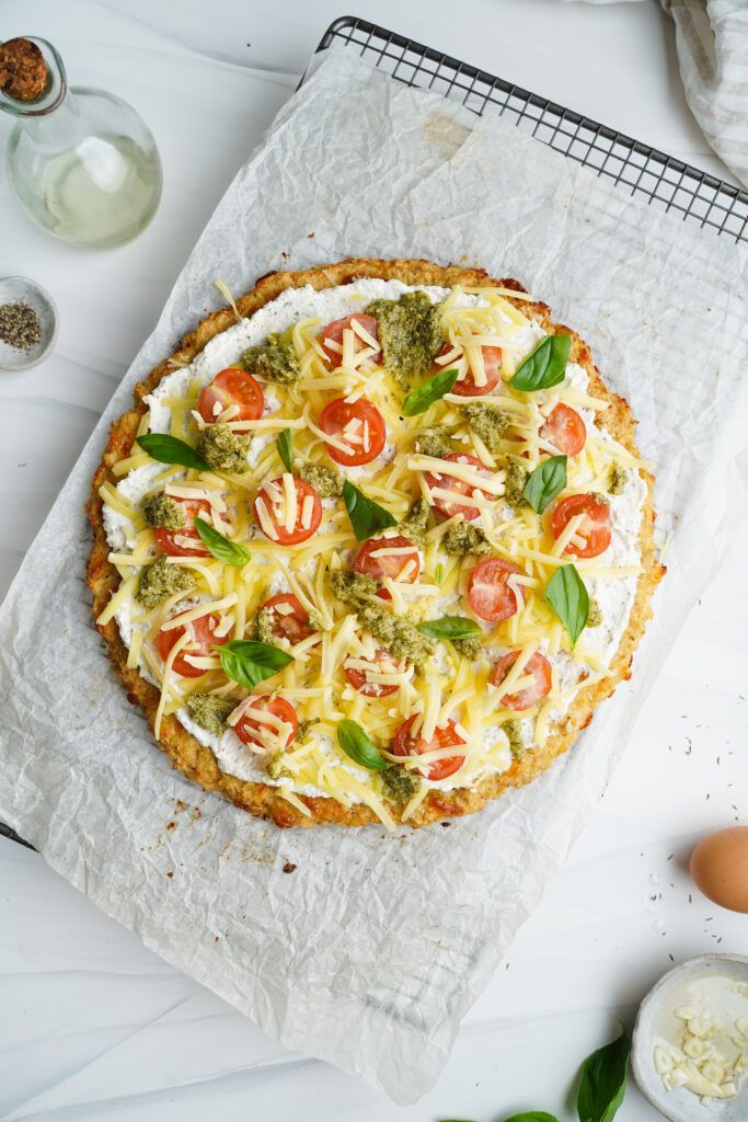 Cauliflower Pizza topped with Cherry Tomatoes, Mozzarella and Fresh Basil | cookingwithcassandra.com