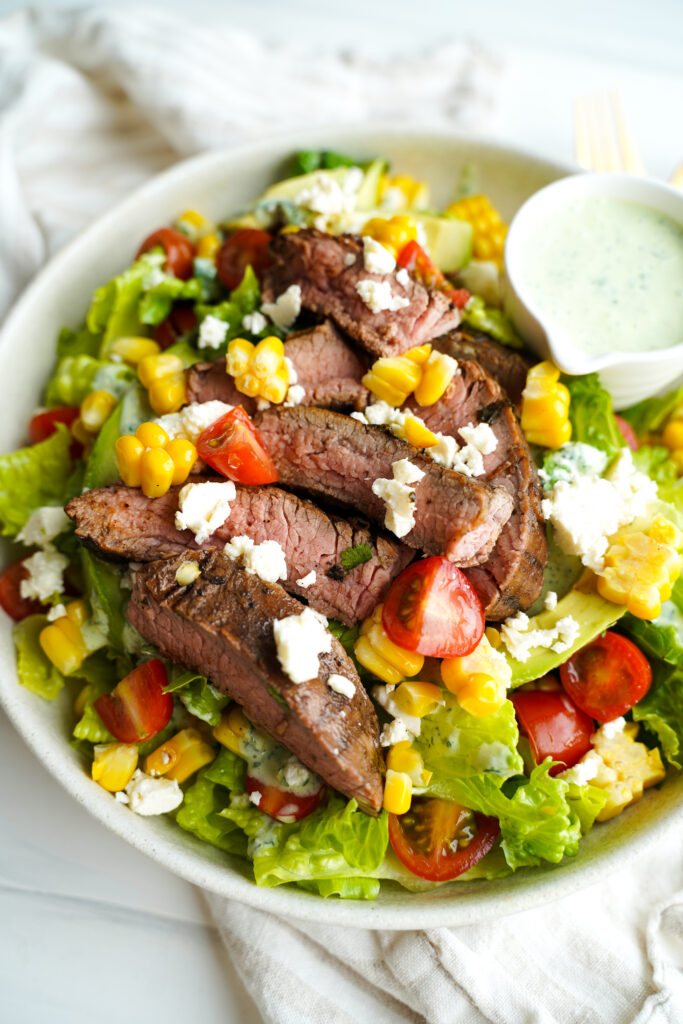 Close up of Steak salad with vegetables, cheese and creamy dressing
