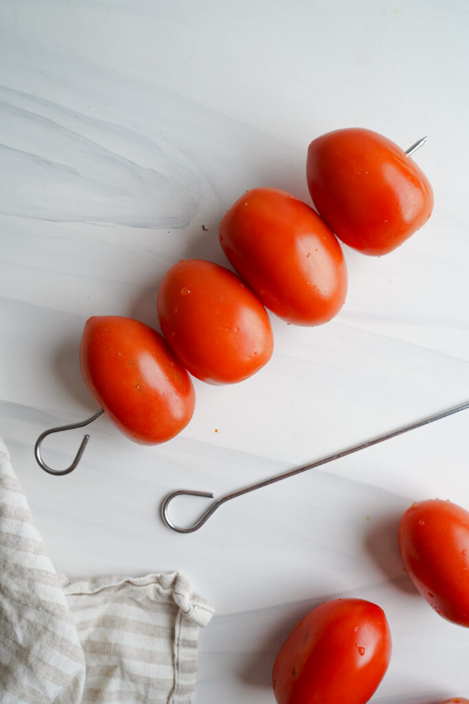Tomato along with metal skewers | cookingwithcassandra.com