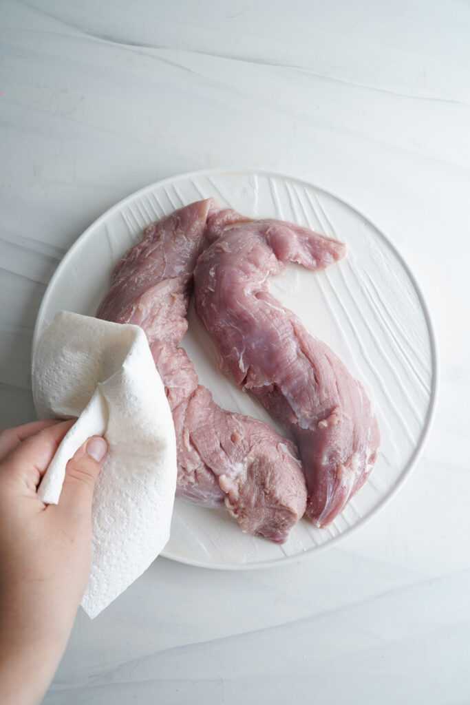 patting pork tenderloin dry with paper towel | cookingwithcassandra.com