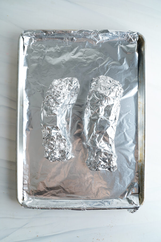 two pork tenderloins wrapped in foil on a sheetpan | cookingwithcassandra.com