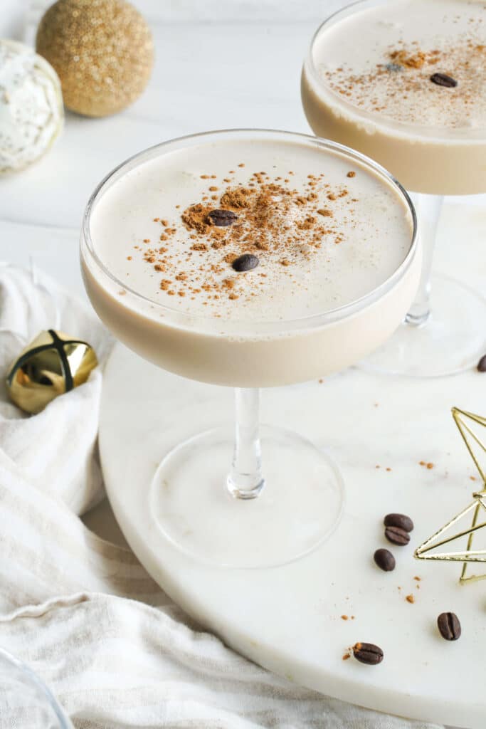 Close-up of a creamy eggnog espresso martini with espresso foam and a light cinnamon garnish