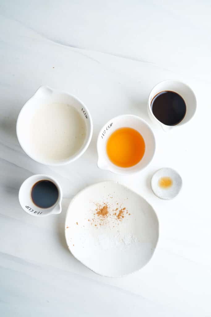 Ingredients for an eggnog espresso martini including eggnog, espresso, rum, and spices