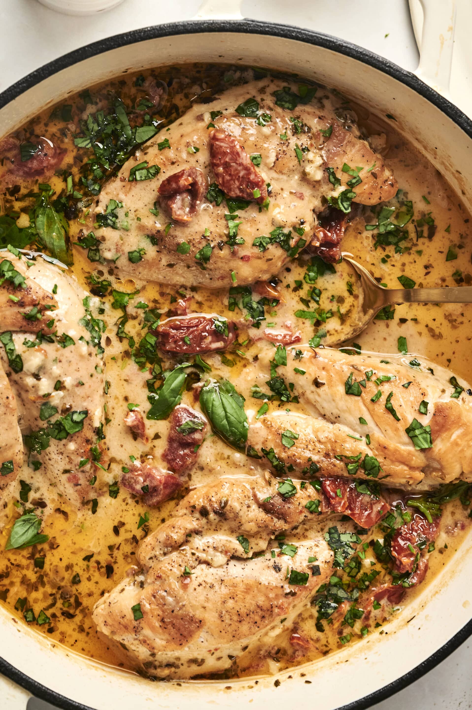 healthy_marry_me_chicken_recipe Boneless chicken breasts in creamy sun-dried tomato sauce with fresh basil in a skillet.