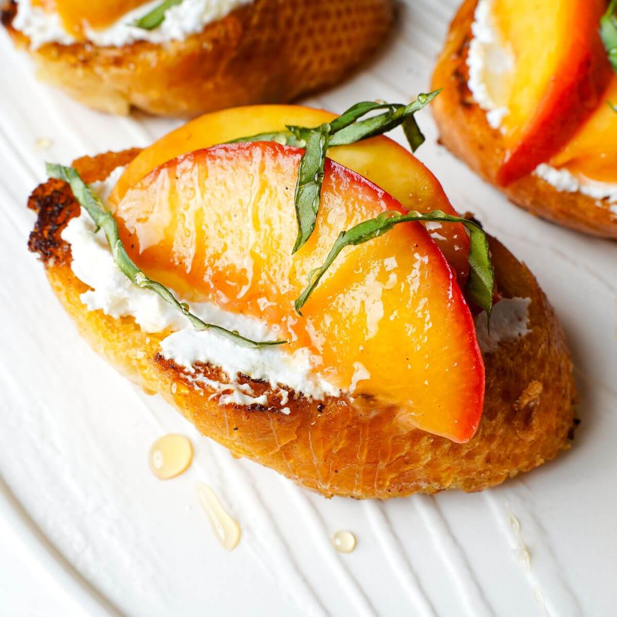 Peach bruschetta with creamy goat cheese, caramelized peaches, honey and fresh basil on toasted baguette.