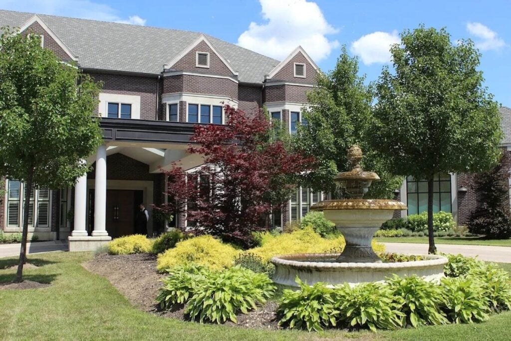 Exterior of The Bruce Hotel in Stratford, Ontario, with landscaped gardens and fountain